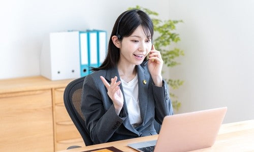 Law firm receptionist on a headset taking a client call at a laptop, illustrating AI call intake for law firms