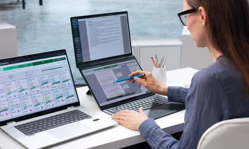 In-house lawyer reviewing contracts on AI legal software across two laptops, illustrating AI-native subscription legal services